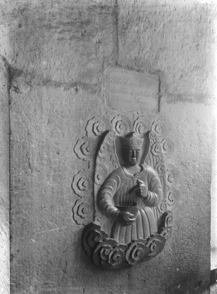 Bức phù điêu Thiên thần cầm bình nước phép chạm nổi trên đá nguyên khối ở lối vào nhà thờ đá. Ảnh: André Salles.