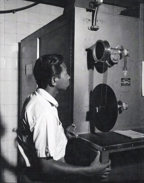 Một kỹ thuật viên xử lý phim 35mm trong phòng tối.