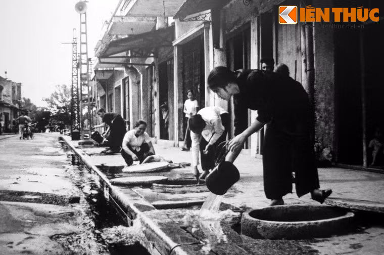 Người dân phố Hàng Đào tát nước khỏi hầm trú ẩn cá nhân năm 1972.
