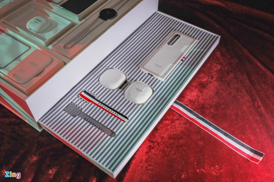 br/> Phần đậm đặc nhất của “ly cà phê Thom Browne” nằm ở ngăn kéo cạnh bên của hộp. Kéo dải dây vải xanh-trắng-đỏ người dùng sẽ nhìn thấy toàn bộ phụ kiện của Galaxy Z Fold3 Thom Browne Edition gồm: ốp da cho smartphone, case tai nghe, 2 bộ dây Galaxy Watch4. Đây cũng là cách đóng hộp của phiên bản đời trước.