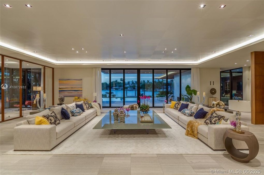 Phòng khách rộng lớn, thoáng đãng với thiết kế cởi mở. Khung cửa lớn mở ra sân vườn phía sau.