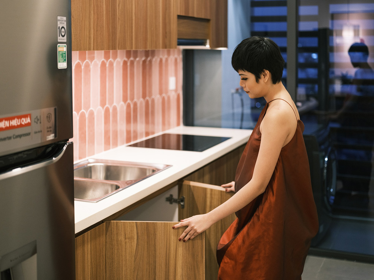 Hệ thống bếp được thiết kế đơn giản với điểm nhấn là mảng tường gạch men màu hồng phấn.