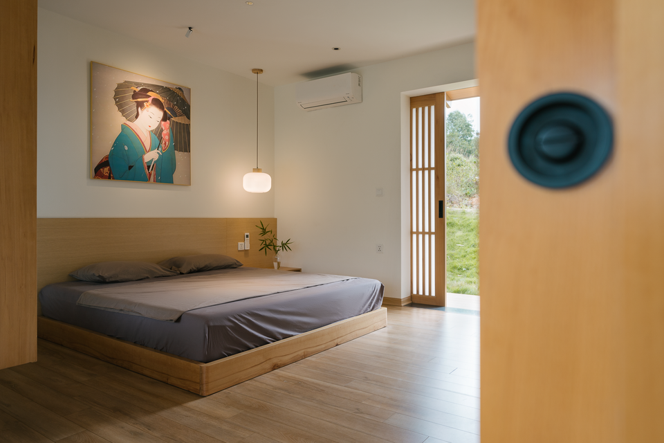 br/> Phòng ngủ tầng 1 có cửa ra phía sau ngôi nhà. Ngoài cửa kính, ngôi nhà còn sử dụng hệ thống cửa lùa xen mica dày và giấy soji truyền thống.