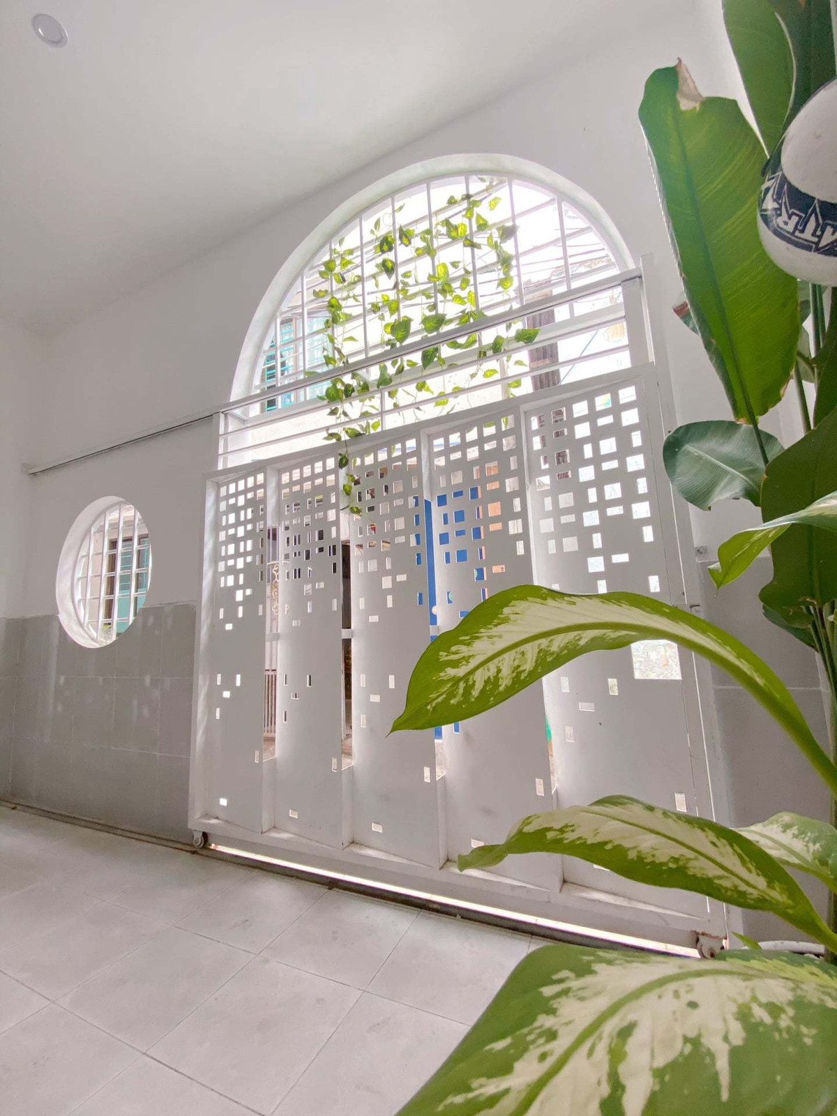 Hiên để xe nho nhỏ xinh xinh, cửa lùa làm bằng sắt tấm đục CNC ban ngày nắng chiếu vào nên hiệu ứng khá đẹp.