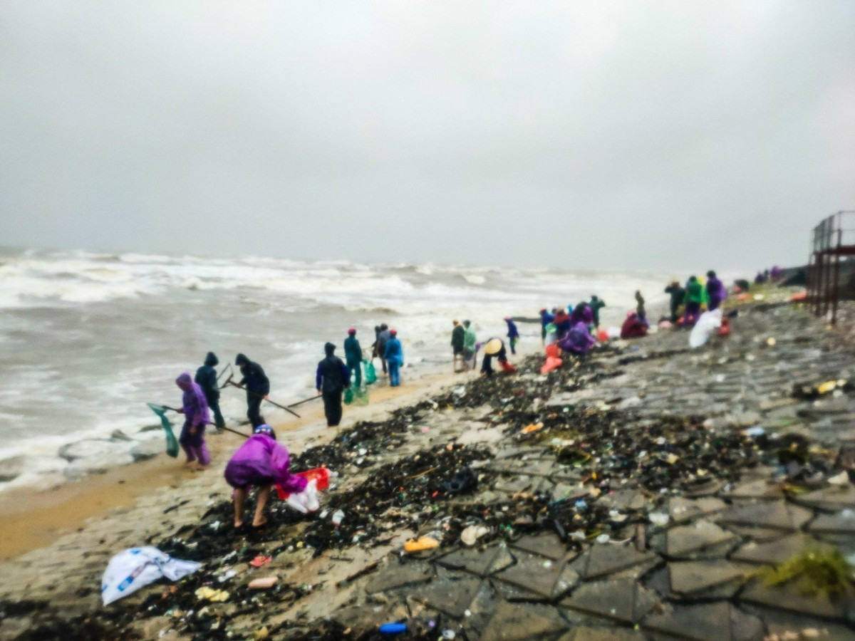 Người dân bất chấp sóng lớn, mưa to, ra dọc bờ để vợt sò mai.