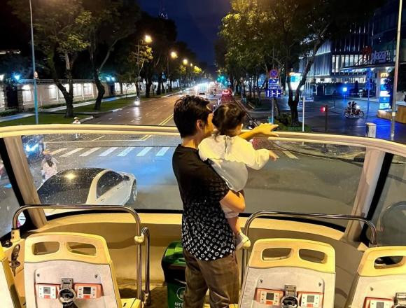 Cường Đô La bế con gái ngắm Sài Gòn sau cơn mưa.