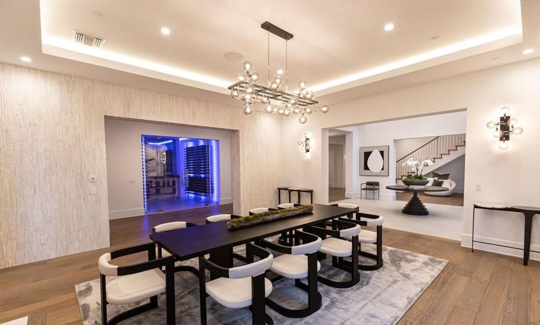 Bàn ăn lớn, đủ chỗ cho 10 người. Nằm sát phòng ăn là một phòng chứa rượu vang hiện đại cùng hệ thống đèn LED tùy chỉnh.