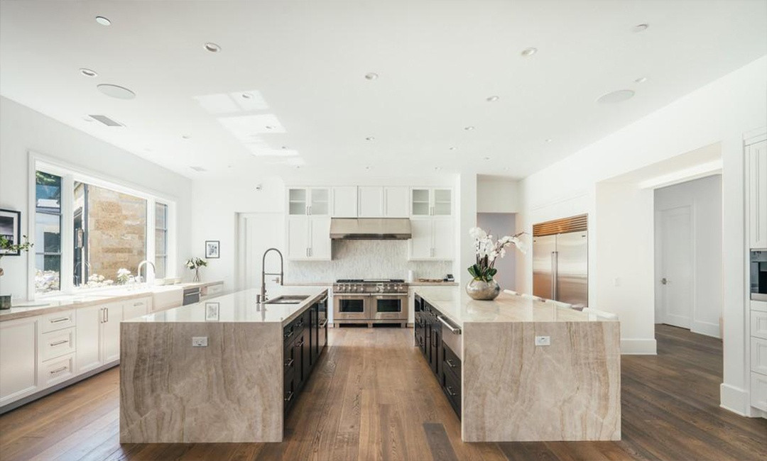 Nhà bếp rộng, nổi bật với hai đảo lớn ốp đá.