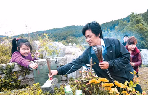 Chiều 30 Tết được cha dẫn đi tảo mộ là kỷ niệm khó quên của Phạm Thủy (21 tuổi, quê Nam Định). "Mỗi năm một lần, hai cha con lại dọn dẹp, thắp hương tại mộ các cụ. Cái Tết xưa dù khó khăn, vẫn luôn toát lên niềm vui và giàu giá trị truyền thống", Thủy nói. Ảnh: Báo Quảng Nam.