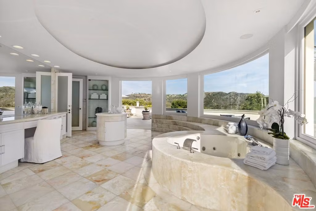 Phòng tắm chính rộng lớn, được trang bị đầy đủ tiện nghi hiện đại, và trông như một spa cao cấp.