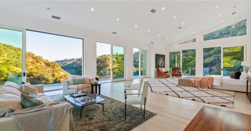 Phòng ngủ chính thoáng đãng được tích hợp với một khu vực tiếp khách và phòng tắm. Năm bộ cửa kính cỡ lớn đem đến ánh sáng tự nhiên và cảnh sắc núi đồi.