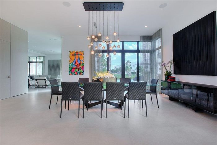 Phòng ăn tuyệt đẹp với những tác phẩm nghệ thuật treo tường đầy màu sắc và đèn chùm xếp tầng.