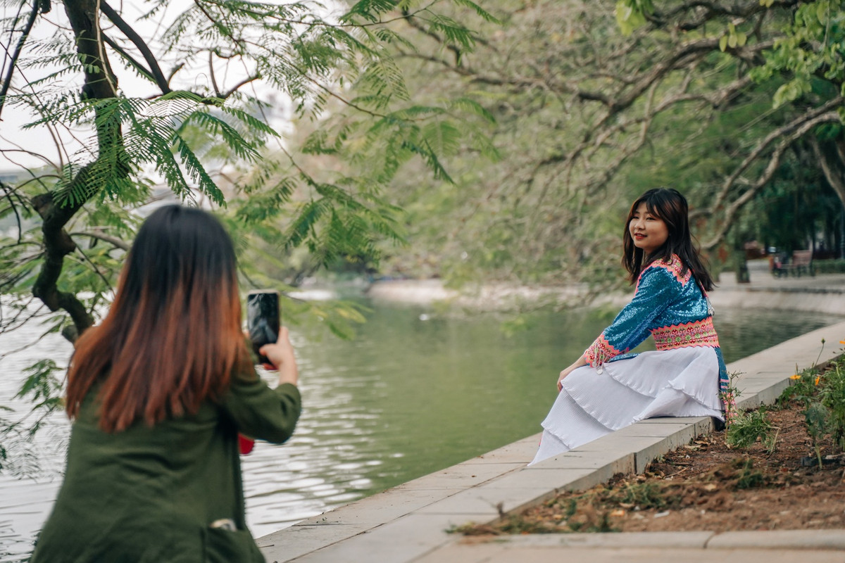 Từ sáng, xung quanh khu vực hồ Hoàn Kiếm, các du khách vừa đi bộ vừa tranh thủ chụp hình. “Mình sinh sống ở vùng núi cao nên xuống dưới Hà Nội không thấy lạnh lắm, vẫn có thể mặc váy dân tộc chụp ảnh”, bạn gái đến từ Yên Bái, chia sẻ.