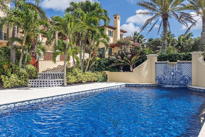 Hồ bơi có thiết kế độc đáo, được bao quanh bởi vườn cây nhiệt đới.