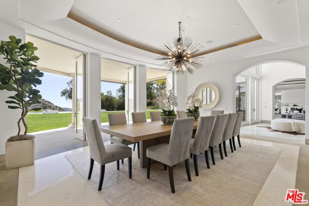 Phòng ăn chính rộng rãi, trang trọng, nổi bật với một chiếc đèn chùm cầu kỳ. Bộ bàn ghế có thiết kế đơn giản, được bài trí tinh tế.