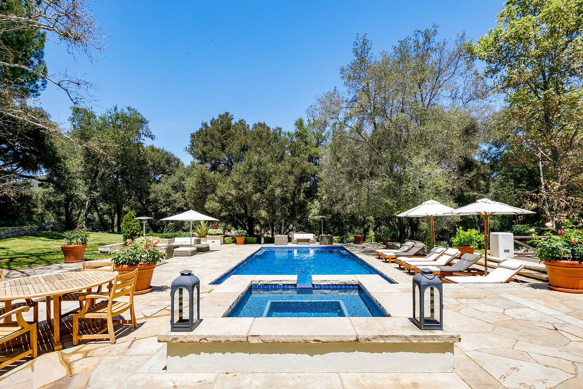 Hồ bơi và bồn ngâm nước nóng ngoài trời được bao quanh bởi hàng cây cao lớn để đảm bảo tính riêng tư cho gia chủ.