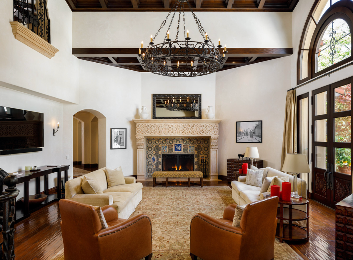 Phòng khách sang trọng, thoáng đãng, nổi bật với chiếc đèn chùm cầu kỳ và chiếc lò sưởi có họa tiết tinh xảo.