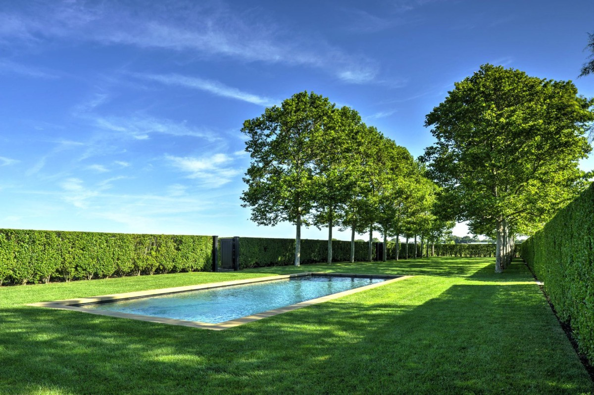 Hồ bơi ngoài trời được bao quanh bởi bãi cỏ xanh mướt, tạo cảm giác gần gũi với thiên nhiên.