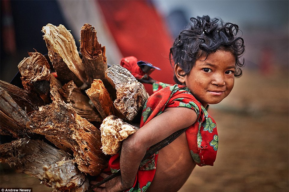 Trong bộ tộc, mọi người đều lao động bất kể tuổi tác, đóng góp sức mình cho cuộc sống chung. Trong hình, một đứa trẻ đang mang củi trên lưng.