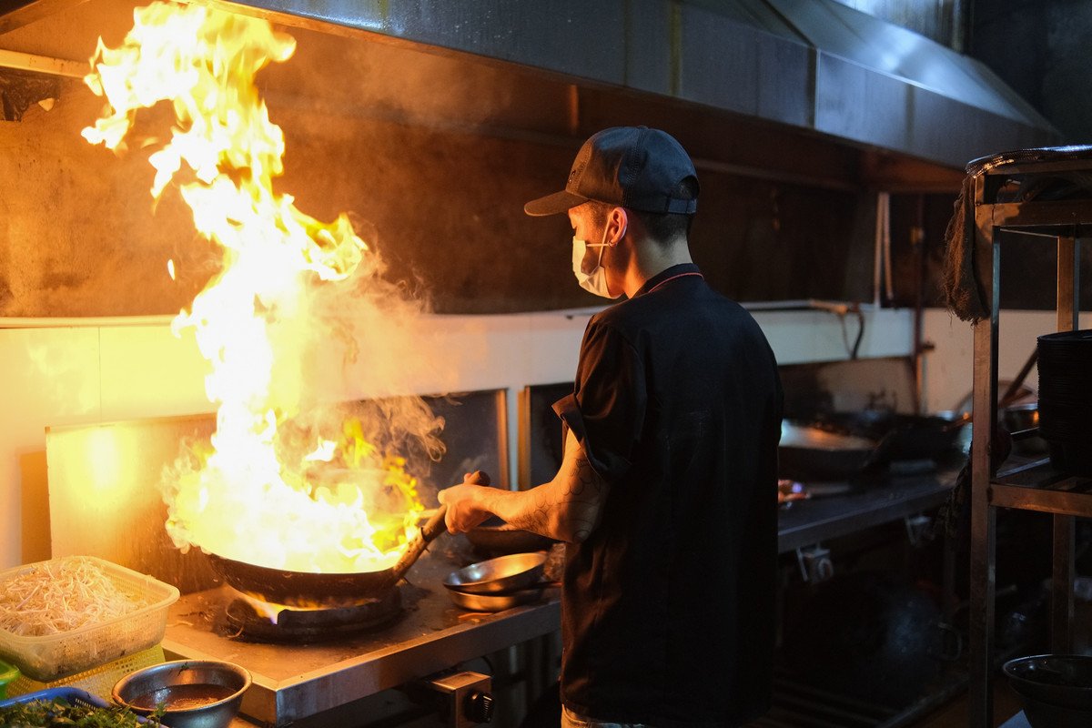 Nguyễn Thành Nam, nhân viên chuyên xào, thường xuyên phải tiếp xúc với bếp lửa. Đặc biệt, trong đợt Euro, lượng đơn tăng mạnh khiến công việc của anh cũng vất vả hơn. "Ngoài trời nóng lại còn gần bếp lửa nên mệt người lắm. Tuy nhiên, mình làm lâu rồi nên cũng quen", anh chia sẻ.