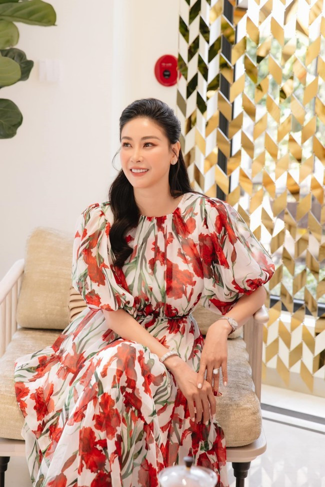 Trong thiết kế mang chất liệu voan tơ đỏ - trắng, Hà Kiều Anh chọn kiểu tóc xoăn nhẹ và lối trang điểm tone cam nhẹ nhàng, kết hợp hài hòa cùng vòng tay, đồng hồ tối giản.