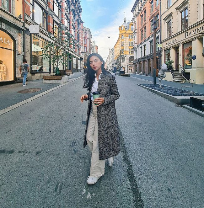 Áo sơ mi trắng + quần ống suông và khoác ngoài áo dáng dài. Outfit này có được sự trẻ trung và thanh lịch, hiệu quả hack tuổi còn được tăng lên khi Ngô Thanh Vân kết lại bộ đồ bằng một đôi sneaker trắng.