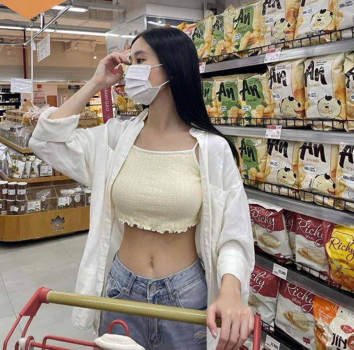 un Vũ cũng khéo léo khoe ưu điểm eo thon với áo hai dây crop-top mix cùng quần jeans và áo sơ mi khoác ngoài năng động.