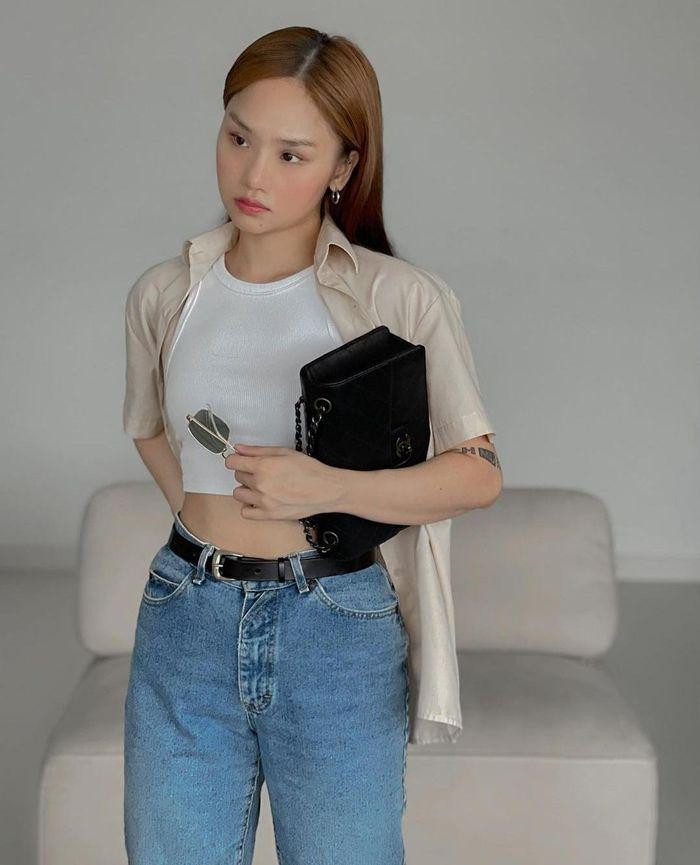 iu Lê chọn trang phục đơn giản mà không kém phần thời trang gồm áo tank top màu trắng phối cùng quần jeans và áo sơ mi khoác ngoài năng động.