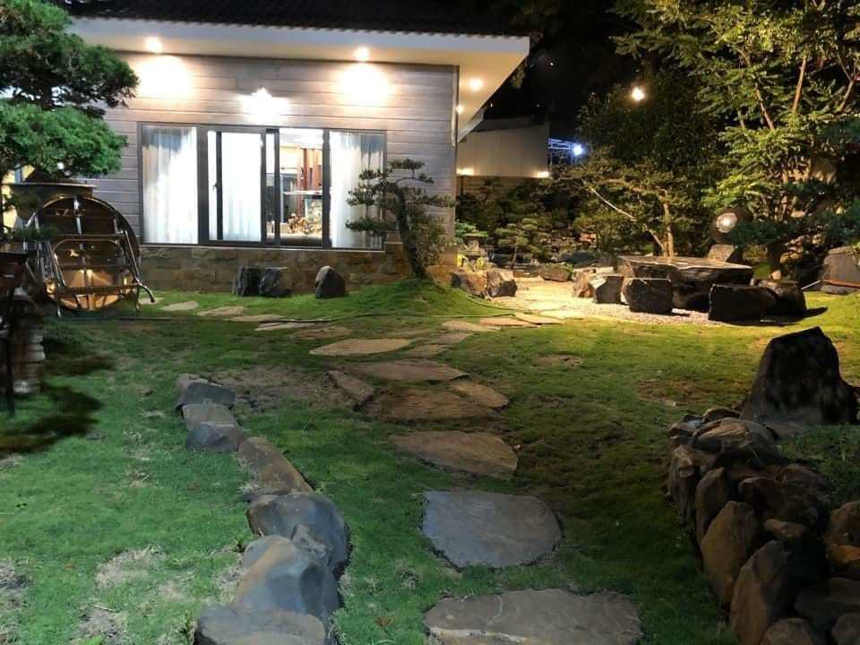 Lối đi đặt phiến đá to bản, trồng cỏ Nhật hai bên.