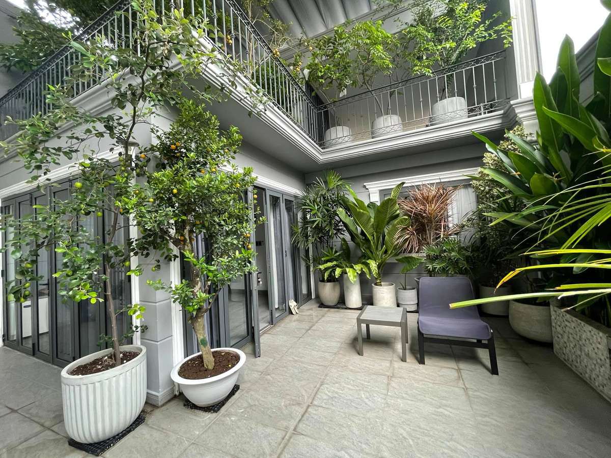 Nha pho voi gian cay thang dung, hoa trai quanh nam ruc ro