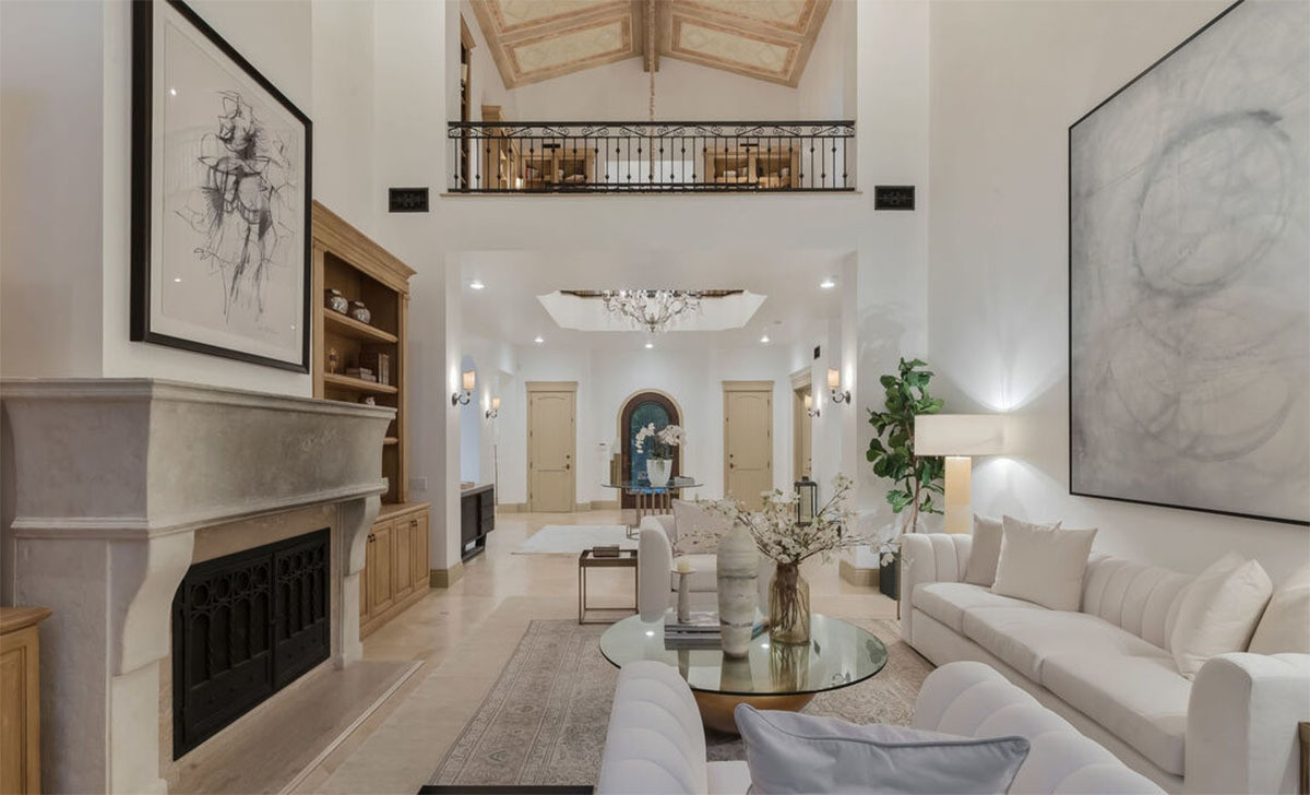 Phòng khách sang trọng, nổi bật với sàn nhà màu be bằng đá và một chiếc lò sưởi cỡ lớn, mang phong cách cổ điển.