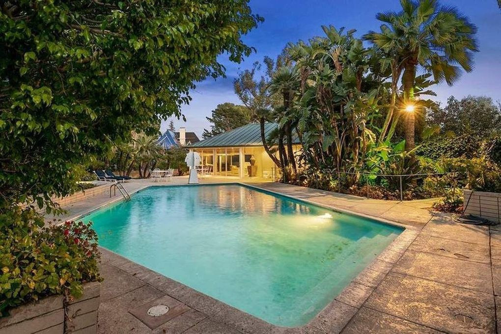 Hồ bơi ngoài trời được bao quanh bởi vườn cây nhiệt đới.