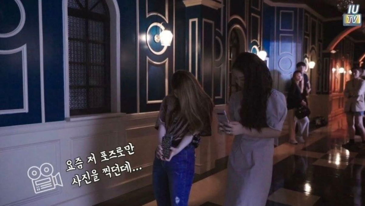 "Gần đây tôi chỉ chụp hình theo cách này thôi", trợ lý của IU chia sẻ trong video. Trước đó, người hâm mộ cũng nhận ra một trong những cách giúp IU trông cao hơn trong ảnh tự chụp là căn tỷ lệ trên màn hình điện thoại. Theo đó, chiều dài màn hình điện thoại được chia làm 3 phần (bật lưới chia tỷ lệ có sẵn trong điện thoại), sau đó canh góc chụp sao cho chiều cao của mẫu chiếm hết 2/3 phần tỷ lệ màn hình. Việc canh góc cho đạt tiêu chuẩn 2/3 phần màn hình cũng giúp người chụp tìm được góc giúp chân dài, người cao.