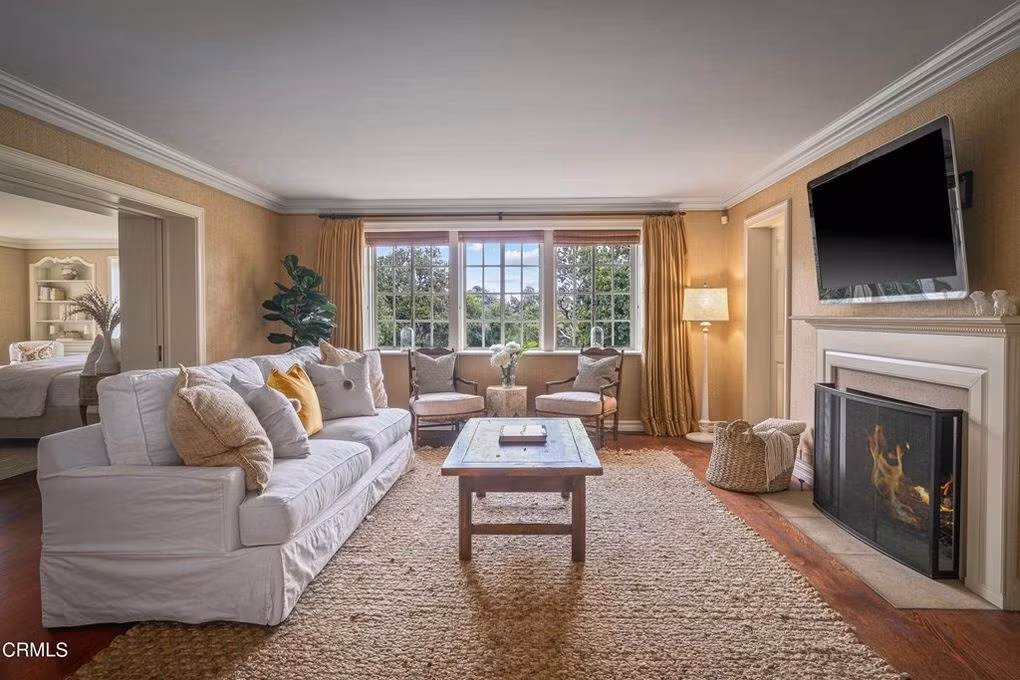 Phòng khách thoáng đãng, sang trọng với điểm nhấn là chiếc lò sưởi và sàn gỗ cứng.