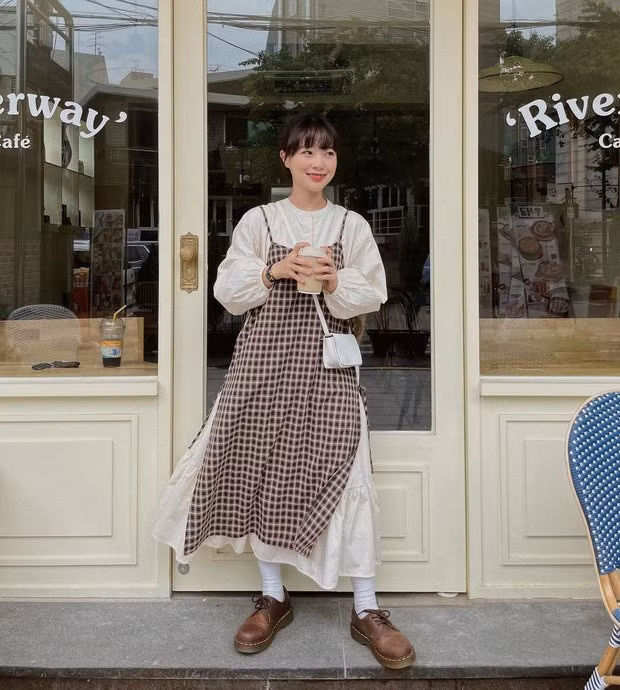 Cô nàng này khoác lên mình 1 set đồ đầy ngọt ngào, dễ thương. Váy tay bồng trắng bên trong, mix cùng váy 2 dây kẻ caro buộc ngang 2 bên hông dù đơn giản nhưng không kém phần xinh xắn.