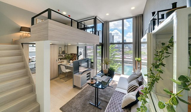 Nằm ở khu chung cư cao cấp bậc nhất Thái Lan, căn hộ này tuy có diện tích nhỏ nhưng có lợi thế là trần cao và tường kính nên không gian sống không đến mức quá chật hẹp. Cách thiết kế hợp lý giúp gia chủ có cuộc sống tiện nghi, hiện đại. Phòng khách được bố trí ở trung tâm, ngăn cách với bếp bằng vách kính và tách biệt với góc làm việc nhờ vách ngăn kệ ti vi. Khu vực gác xép là nơi dành riêng cho phòng ngủ.