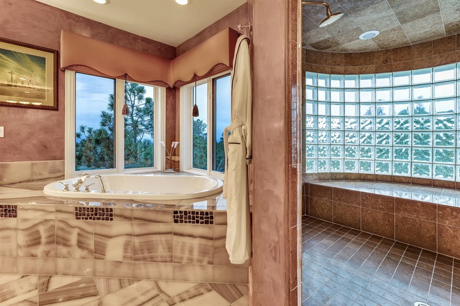 Phòng tắm chính rực rỡ, mang tông màu hồng chủ đạo và được lát đá mã não sang trọng.