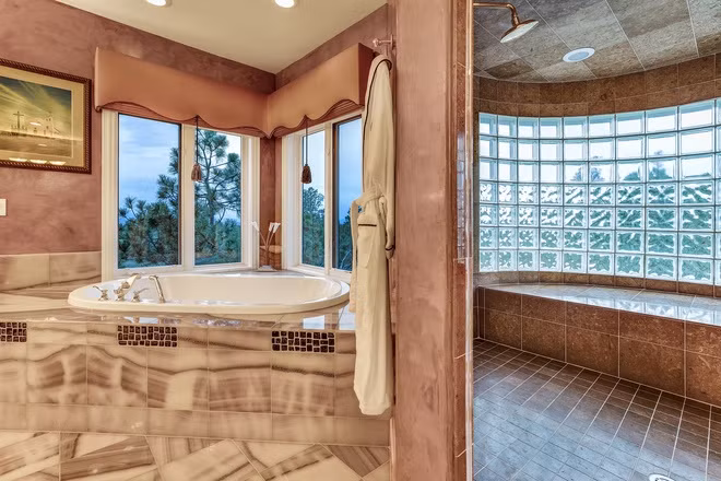 Phòng tắm chính rực rỡ, mang tông màu hồng chủ đạo và được lát đá mã não sang trọng.