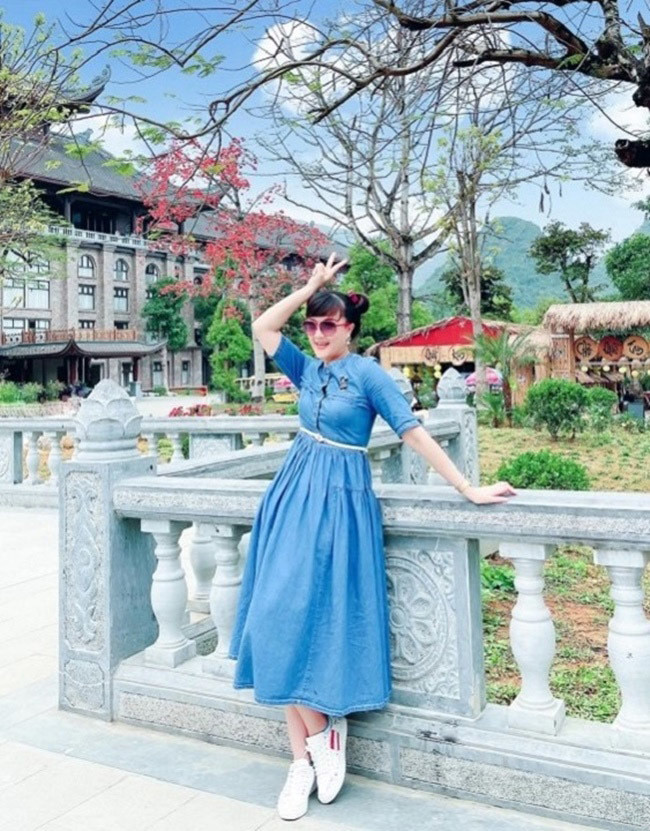 Với nụ cười thường trực trên môi, danh hài luôn lan tỏa niềm vui và nguồn năng lượng tích cực đến mọi người. Cô chọn váy denim tay lửng, phối cùng mắt kính đỏ và sneakers trắng tạo nên vẻ năng động và tràn đầy sức sống.