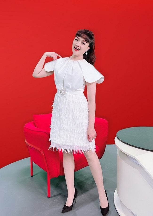 br/> Nữ diễn viên “Những ngày không quên” đài các khi diện váy trắng nổi bật trên nền đỏ. Chiếc váy có phần phủ vai được cắt và xếp ly tinh tế, chân váy xếp lớp tua rua với điểm nhấn là bông hoa 4 cánh. Cô chọn màu son đỏ tươi nổi bật và kiểu tóc buộc cao “hack tuổi”.