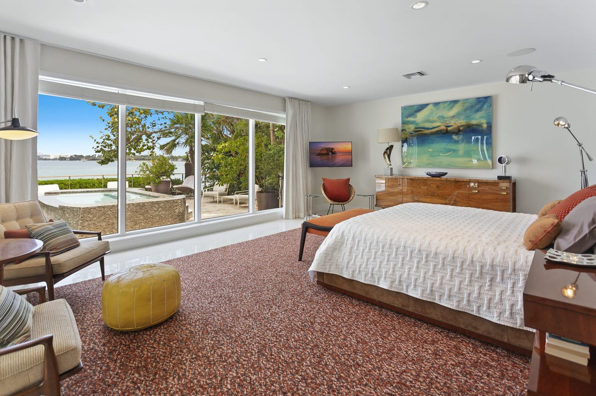 Phòng ngủ thanh lịch, ấm cúng. Bức tường kính đem đến ánh sáng và khung cảnh thiên nhiên.