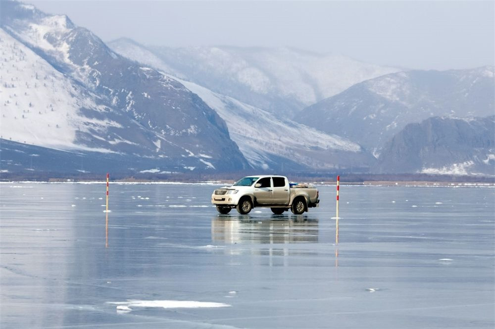Một chiếc ô tô con đi trên bề mặt đóng băng của hồ Baikal về phía đảo Olkhon.