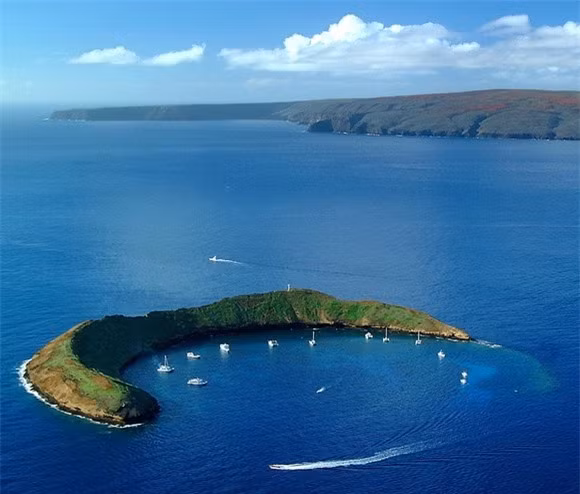5. Núi lửa Molokini, Hawaii, Mỹ: Núi lửa Molokini nổi tiếng có hình mặt trăng khuyết thường bị photoshop điểm thêm một hòn đảo tí xíu bên cạnh để giống như mặt trăng và 1 ngôi sao. Thực tế chỉ có duy nhất mỏm đá mặt trăng mà thôi, nó là một phần của miệng núi lửa bị ngập trong nước. Mỏm đá mặt trăng này trở thành một hòn đảo nhỏ ở kênh dải quần đảo Alalakeiki. Molokini là điểm hẹn lý tưởng của dân yêu lặn biển, lướt ván.