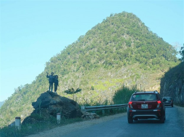 Hai bạn nhỏ cố trèo lên cao để được nhìn đoàn xe. Rất nhiều người tham gia hành trình nói rằng, sự hồn nhiên, nụ cười tươi trên gương mặt của những em bé Hà Giang là một phần không bao giờ quên trong ký ức của chuyến đi lịch sử. 