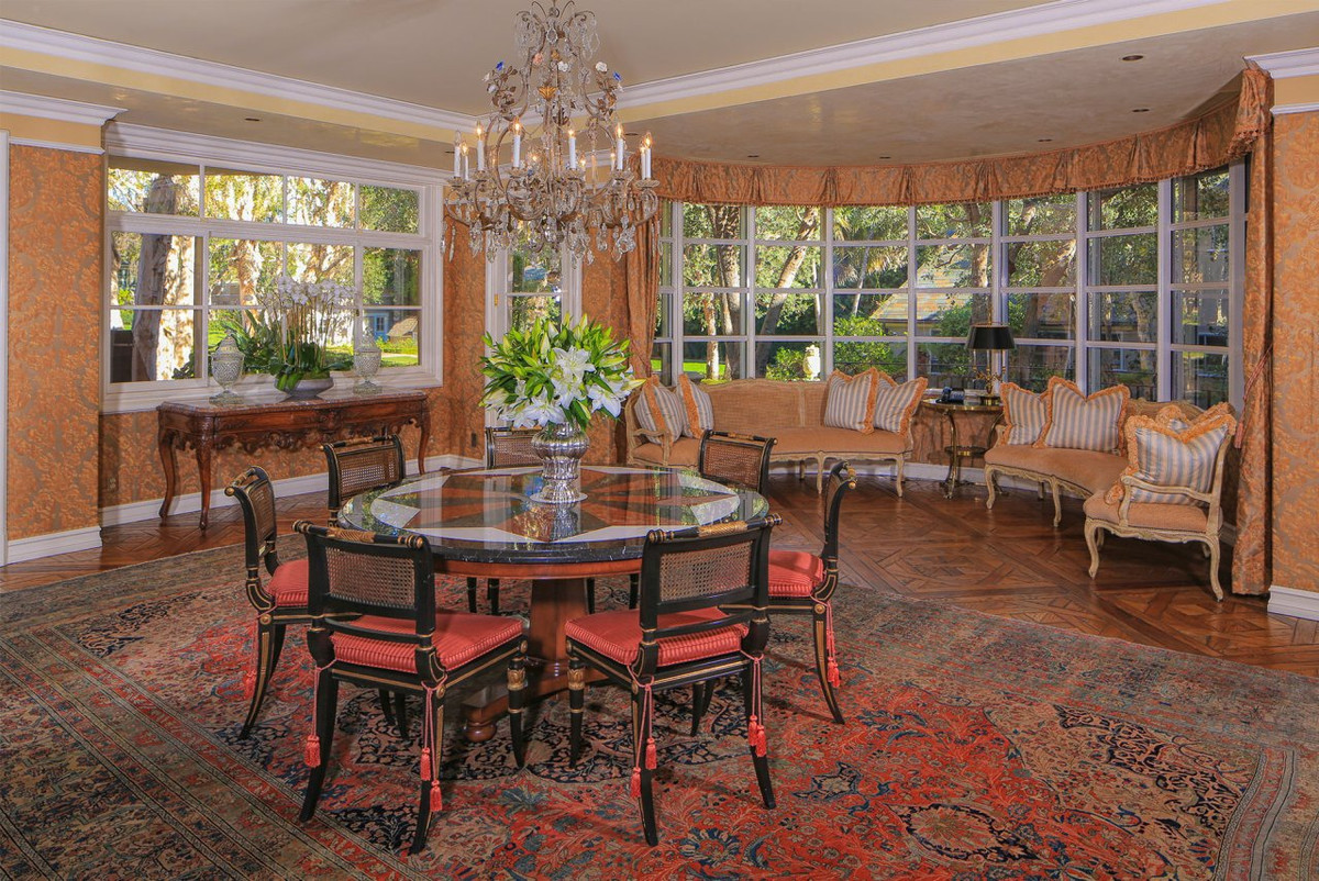 Khu vực ăn uống rộng lớn, nổi bật với chiếc đèn chùm tinh xảo. Các khung cửa kính bao quanh đem đến ánh sáng tự nhiên và cảnh sắc sân vườn.