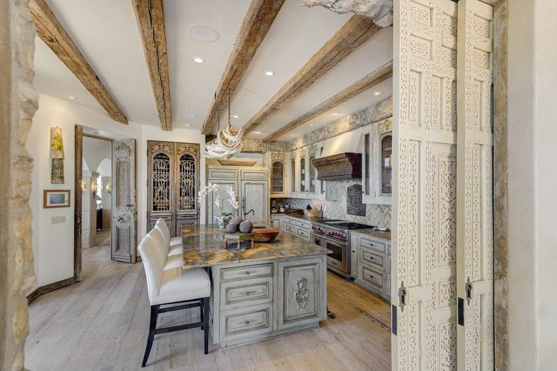 Nhà bếp rộng lớn, mang những đường nét cổ điển, được trang bị nội thất và thiết bị nấu nướng cao cấp. Điểm nhấn tại đây là chiếc đèn chùm được làm từ cây nho rừng Amazon.