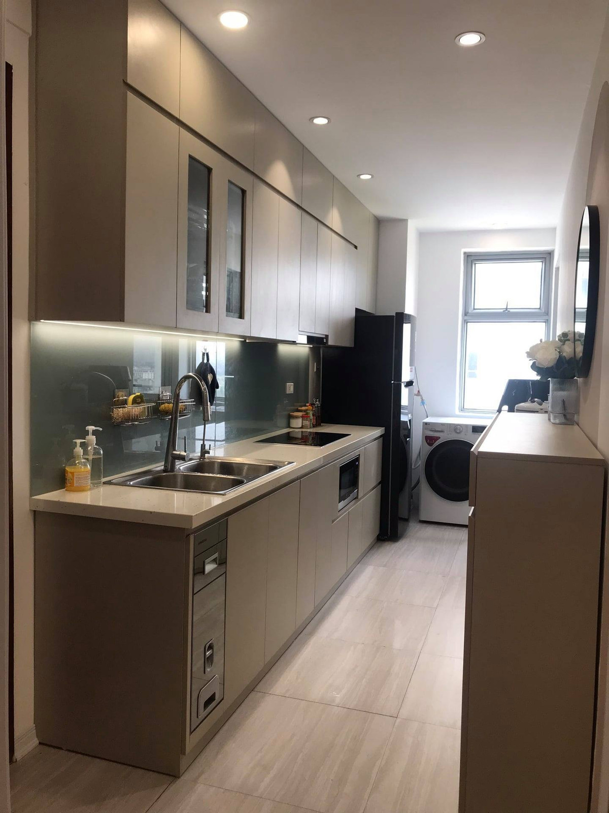 Đối diện tủ giày là bếp nấu và khu để máy giặt sấy, tủ lạnh.