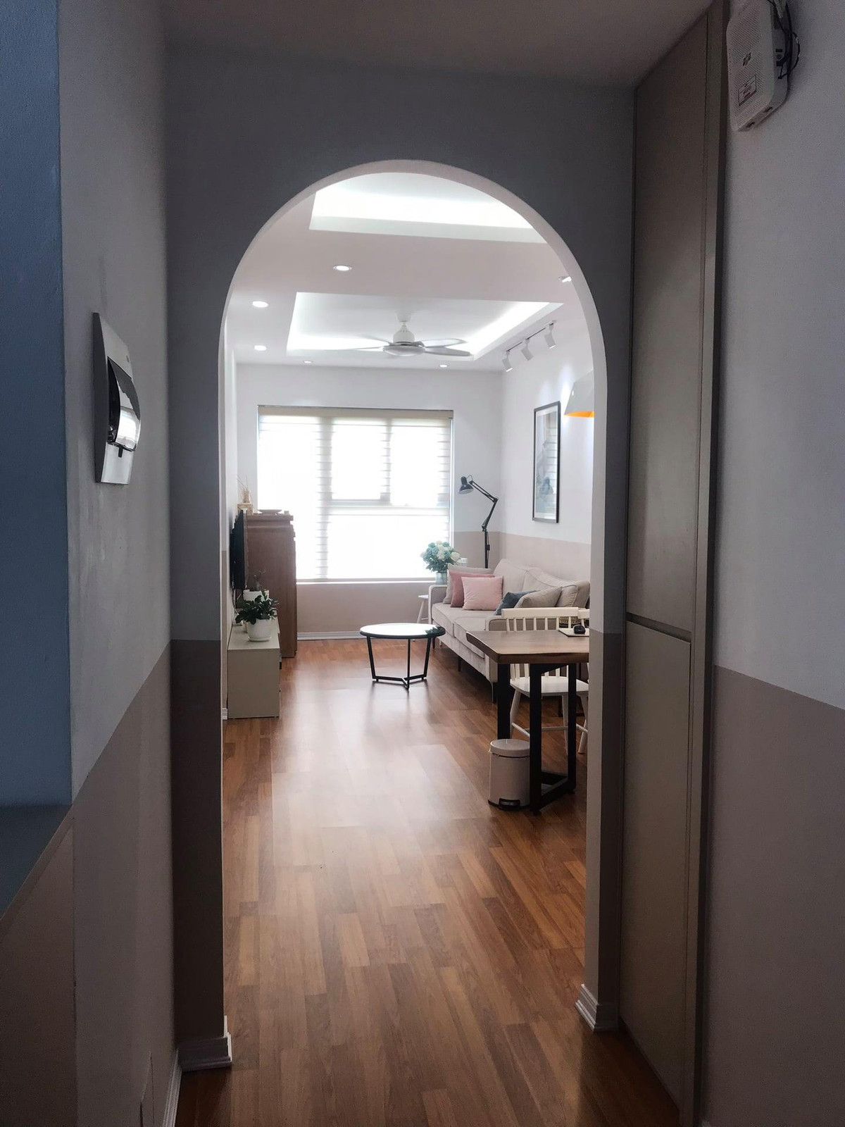 Đây là lối vào, phần bị giật gấp ở hiện trạng, kiến trúc sư Lê Hòa làm vách thạch cao để cho phòng khách được vuông. Phần còn thừa, anh đóng một cái tủ làm kho.