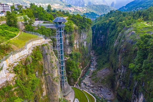 br/> Khenứt mặt đất Yunlong được hình thành cách đây ít nhất 50 triệu năm,nó liên tục bị xói mòn trên bề mặt và tạo thành các hố sụt, sôngngầm bên dưới. Dưới ảnh chụp từ trên không, nó trông giống như một“vết sẹo” khổng lồ.Nếu như bạn không thích leo núi, có thể sử dụngthang máy tại đây. Thang máy được xây dựng thẳng đứng dọc theo ngọnnúi, cao 130m.