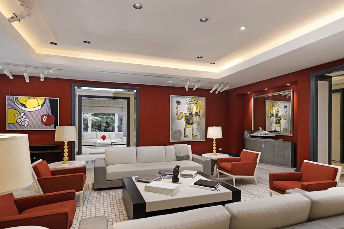 Phòng khách gây ấn tượng với gam màu đỏ thẫm bắt mắt, bộ sofa cỡ lớn, và những tác phẩm nghệ thuật độc đáo.